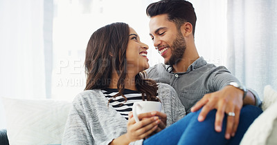 Buy stock photo Cropped shot of an affectionate young couple cuddling with each other while in their living room during the day