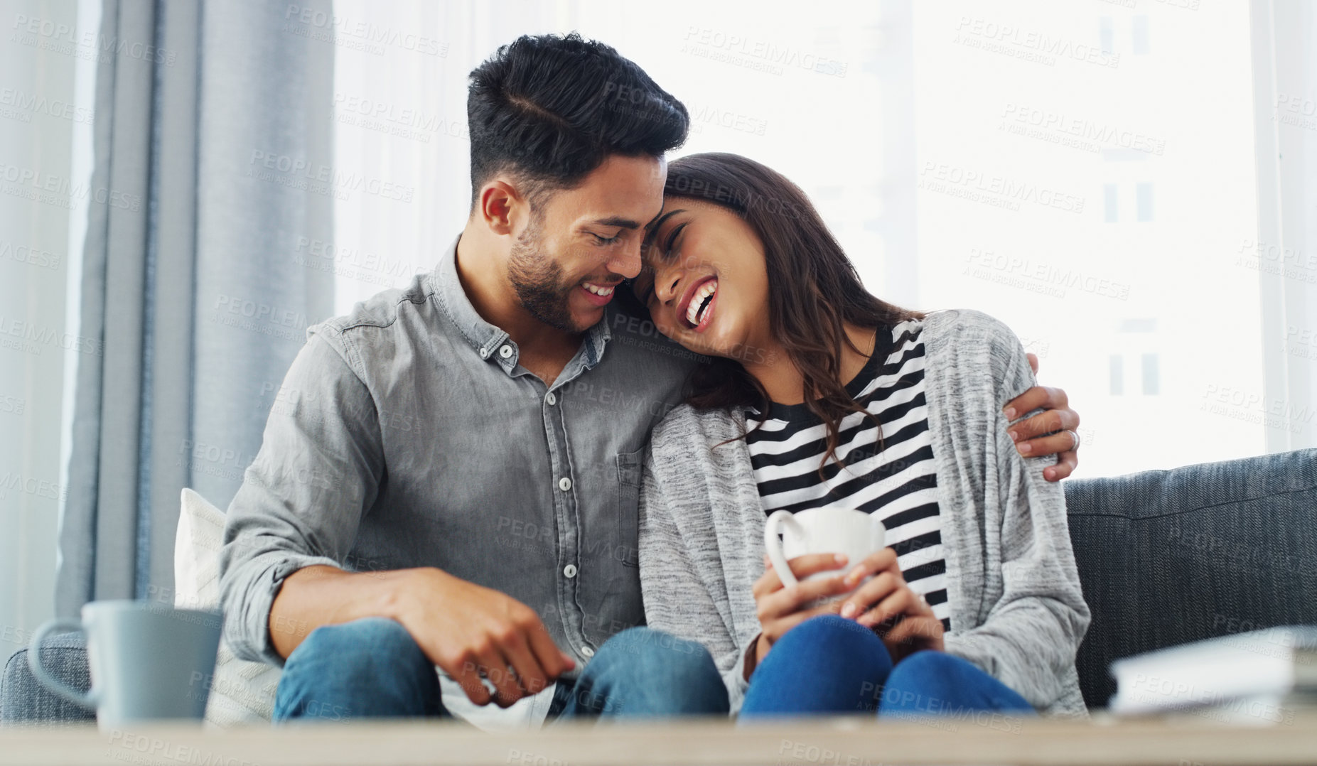 Buy stock photo Cropped shot of an affectionate young couple holding each other while in their living room during the day