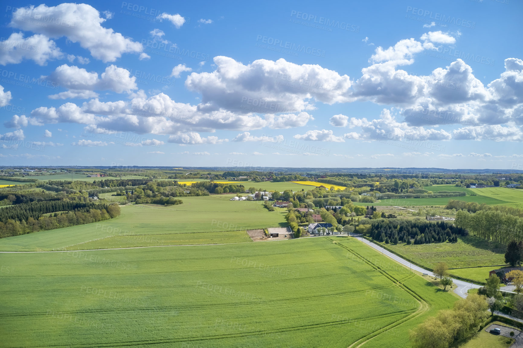 Buy stock photo Drone view of farming and agricultural fields outdoors in Europe during summer or spring. Vibrant and bright pastures growing on endless farmland with blue sky background over a vast and open meadow