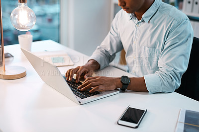 Buy stock photo Shot of an unrecognizable businessman working on his laptop during a late night shift at work