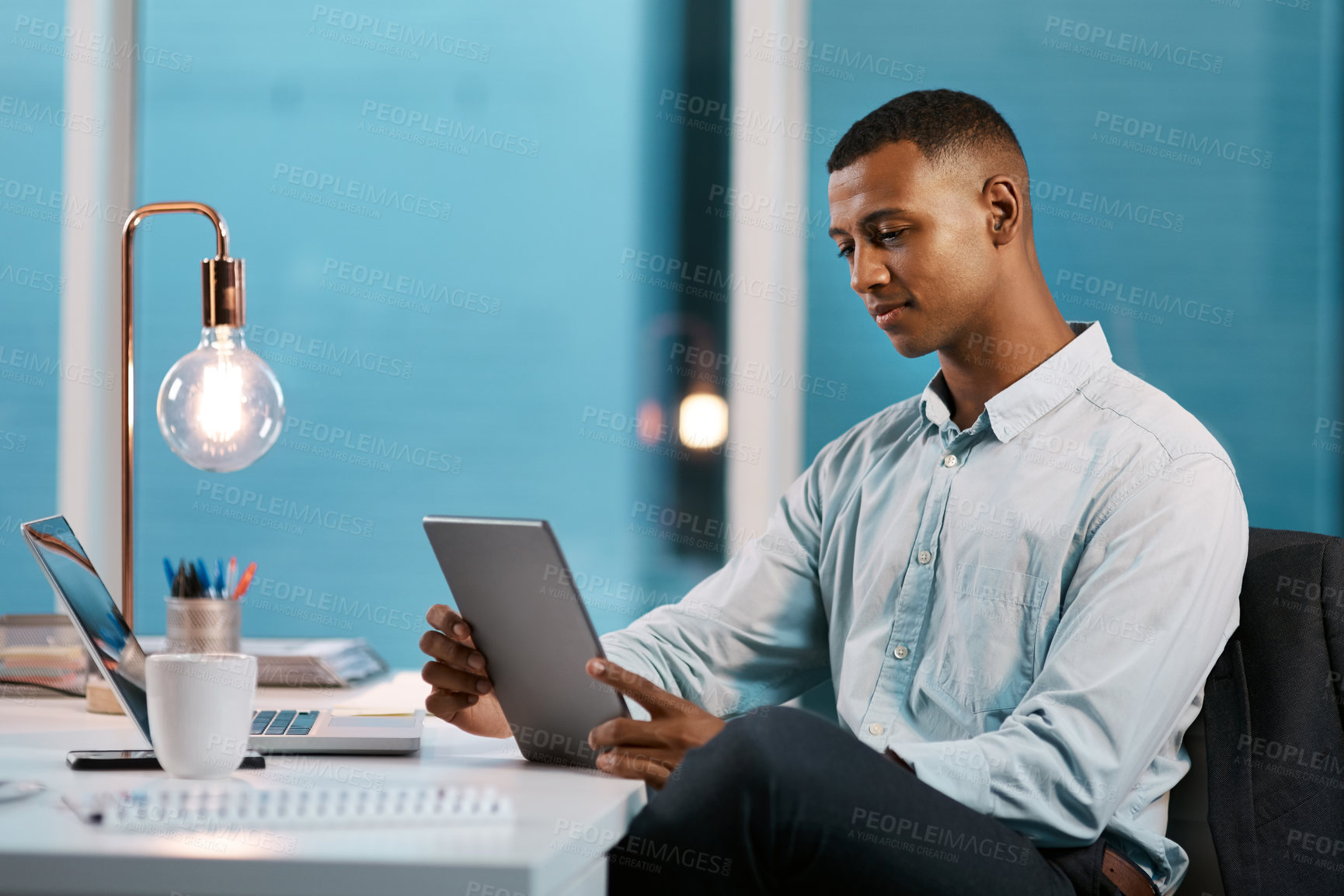 Buy stock photo Night, black man and smile on tablet at office on table with light bulb on research, communication and networking. Male person, accountant and corporate on deadline or overtime for project in Atlanta