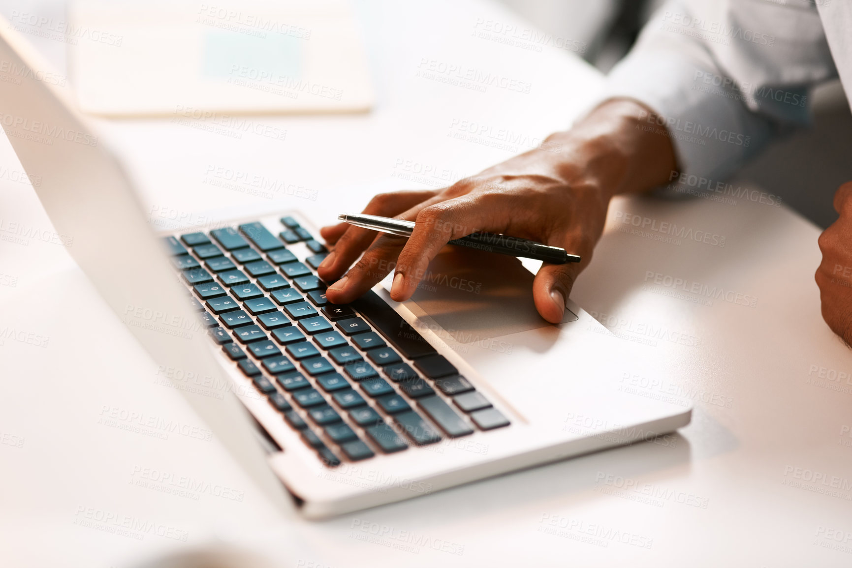 Buy stock photo Shot of an unrecognizable businessman working on his laptop during a late night shift at work