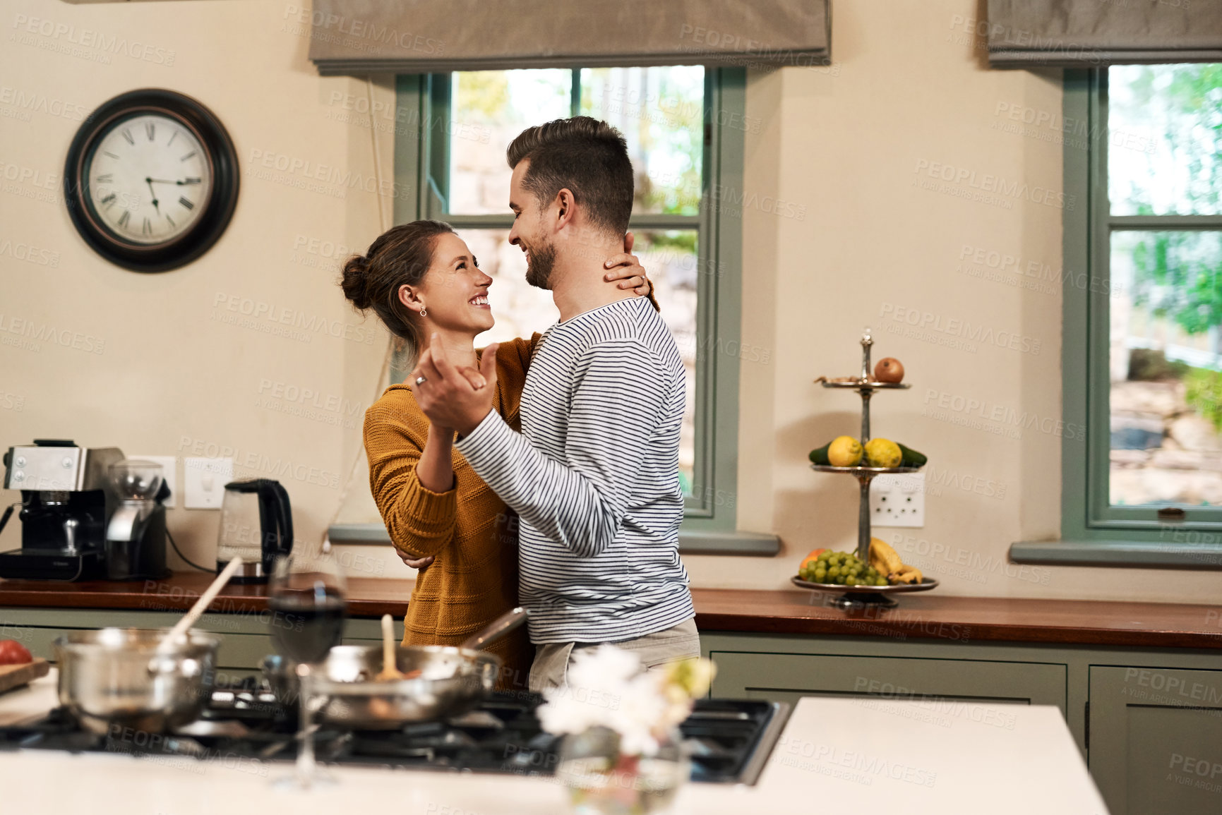 Buy stock photo Smile, couple and dance with love in kitchen for bonding, romantic connection and sweet embrace for relationship. Man, woman and holding hands in home with rhythm for affection, care and compassion.