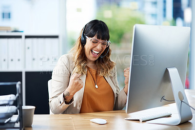 Buy stock photo Cropped shot of an attractive young businesswoman celebrating while wearing a headset in her office during the day