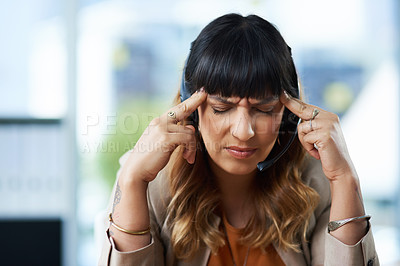 Buy stock photo Cropped shot of an attractive young businesswoman suffering from a headache while in her office during the day