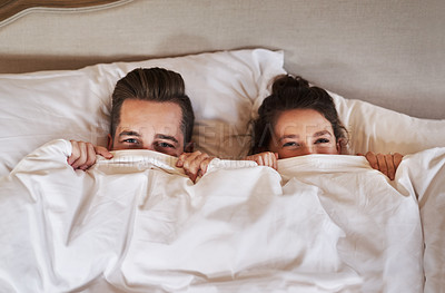 Buy stock photo Couple, bed and portrait with love, care and commitment together at home with hiding under blanket. Morning, marriage and anniversary with silly, fun and happy people with romance and duvet cover