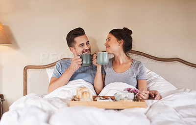 Buy stock photo Drinking coffee, happy couple and breakfast in bed for relax, love and bonding in home. Morning, woman and man with tea in bedroom for romance, care and eating healthy food on anniversary together