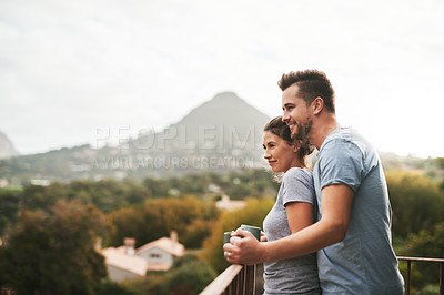 Buy stock photo Shot of an affectionate young couple drinking coffee while standing on their balcony at home in the morning