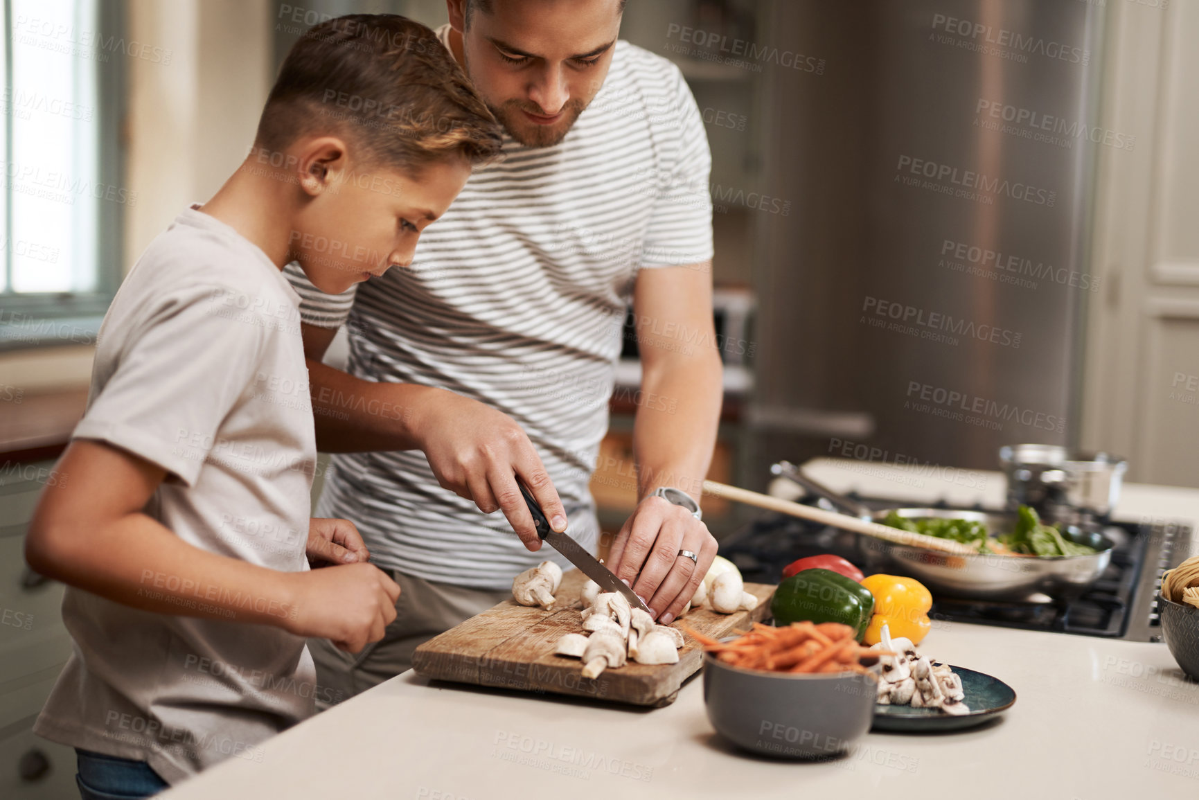 Buy stock photo Cooking, father and son in kitchen, cutting vegetables and ingredients with time together, hobby and child development. Parent, dad or boy with nutrition, learning and help with support and skills