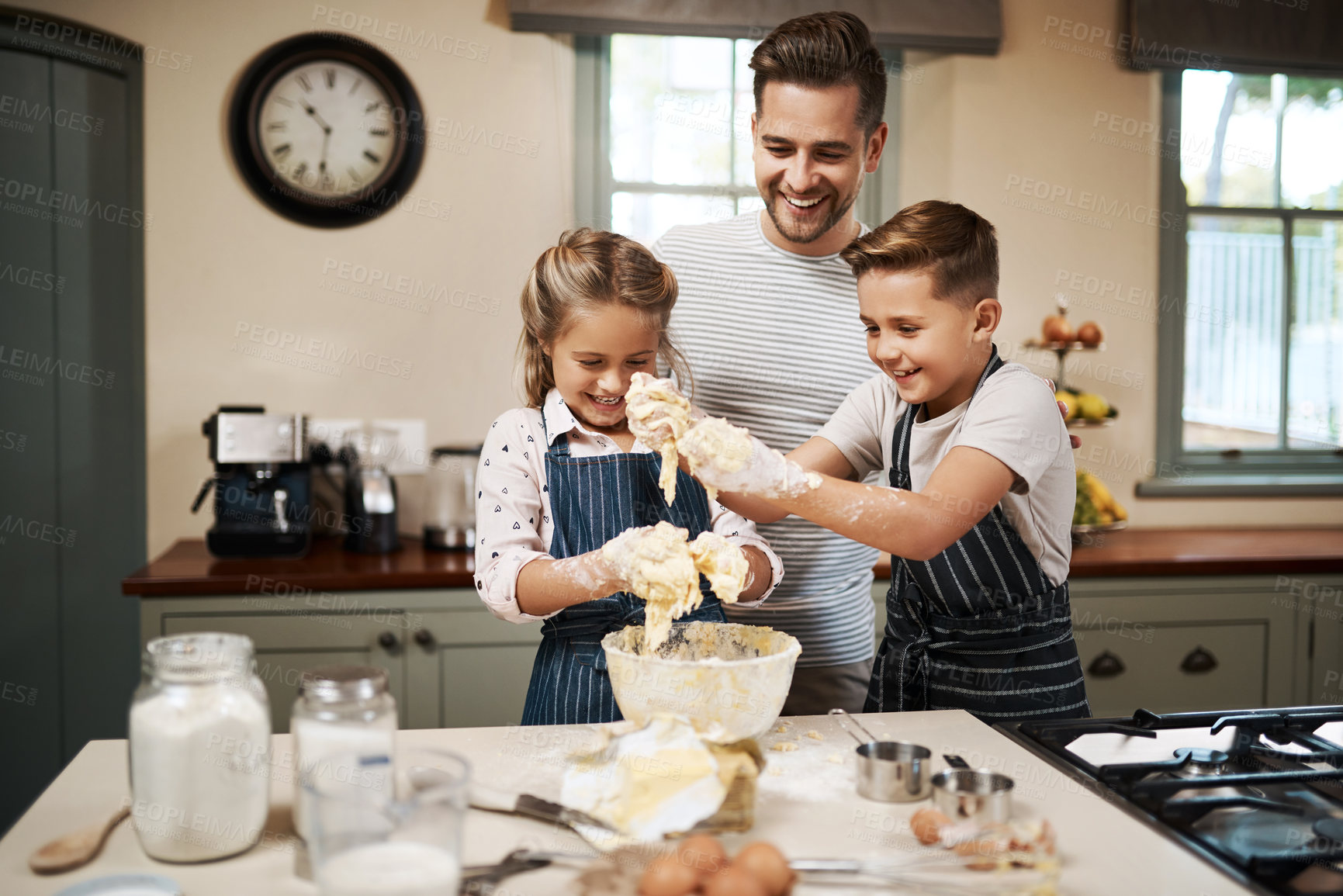 Buy stock photo Shot of a man and his two children baking in the kitchen at home
