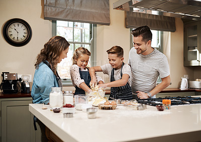 Buy stock photo Cropped shot of a young family baking in the kitchen at home