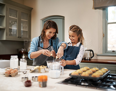 Buy stock photo Shot of a woman and her daughter baking together in the kitchen