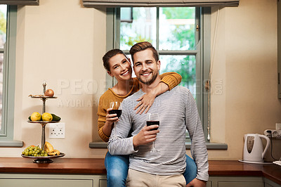 Buy stock photo Cropped portrait of an affectionate young couple holding wine glasses in their kitchen at home