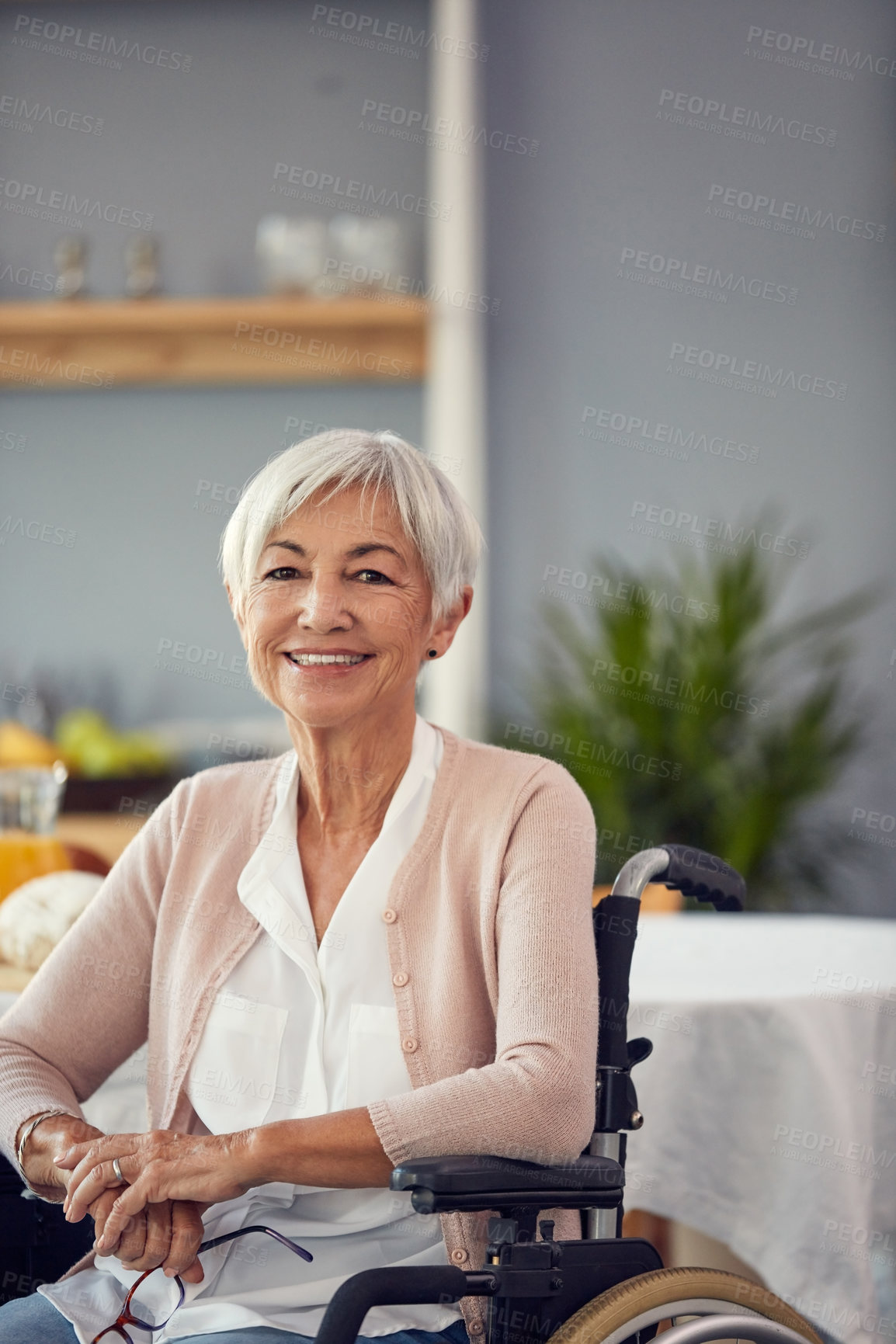Buy stock photo Cropped portrait of a happy senior woman smiling while sitting in her wheelchair in a retirement home