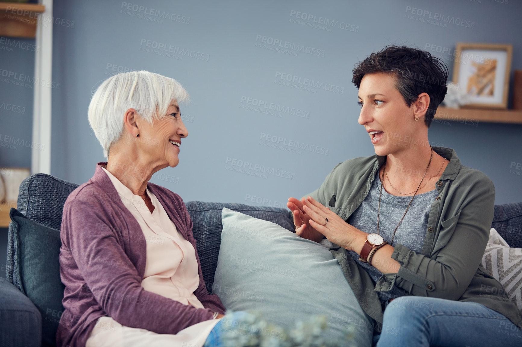 Buy stock photo Cropped shot of an affectionate  young woman having a conversation with her senior mother in their living room at home