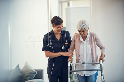 Buy stock photo Cropped shot of a young nurse assisting a senior woman walk using a walker in a nursing home