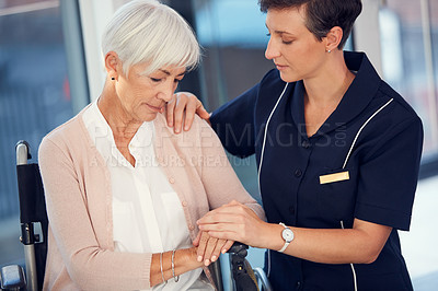 Buy stock photo Cropped shot of a young female nurse consoling an aged woman sitting in a wheelchair in a nursing home