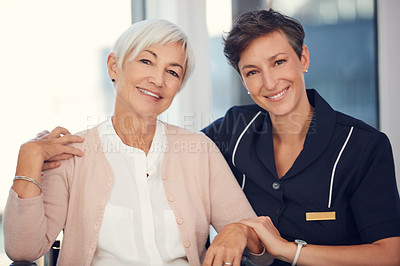 Buy stock photo Cropped portrait of a young female nurse embracing a senior woman sitting in a wheelchair in a nursing home