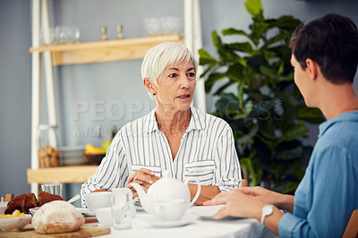 Buy stock photo Cropped shot of an affectionate senior woman having tea with her daughter on a dining table at home