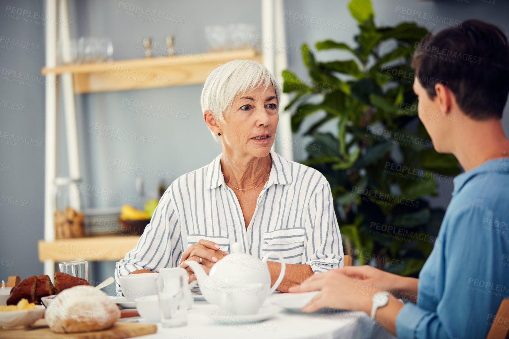 Buy stock photo Cropped shot of an affectionate senior woman having tea with her daughter on a dining table at home