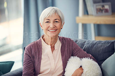 Buy stock photo Cropped portrait of a happy senior woman relaxing comfortably on her couch at home