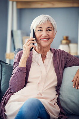 Buy stock photo Cropped shot of a happy senior woman taking a phonecall while relaxing on her couch at home
