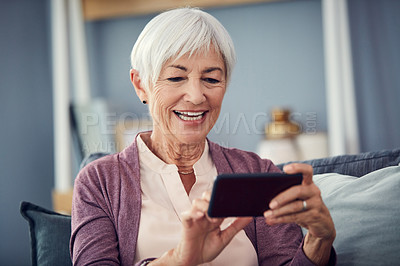 Buy stock photo Cropped shot of a happy senior woman using a smartphone to make a video call on her couch at home