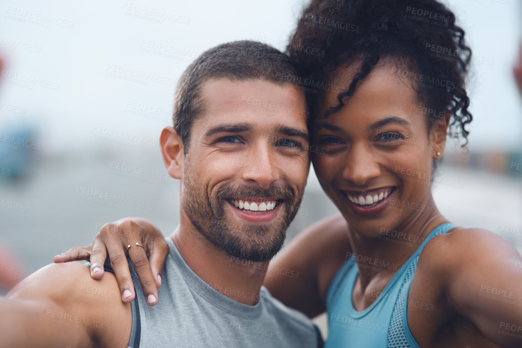 Buy stock photo Portrait of a sporty young couple taking selfies together while exercising outdoors