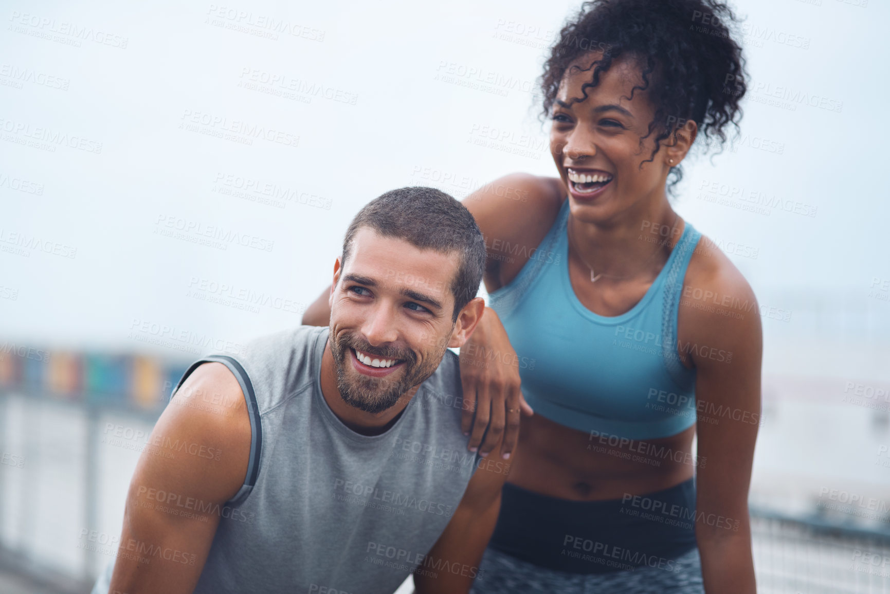 Buy stock photo Shot of a sporty young couple taking a break while exercising outdoors