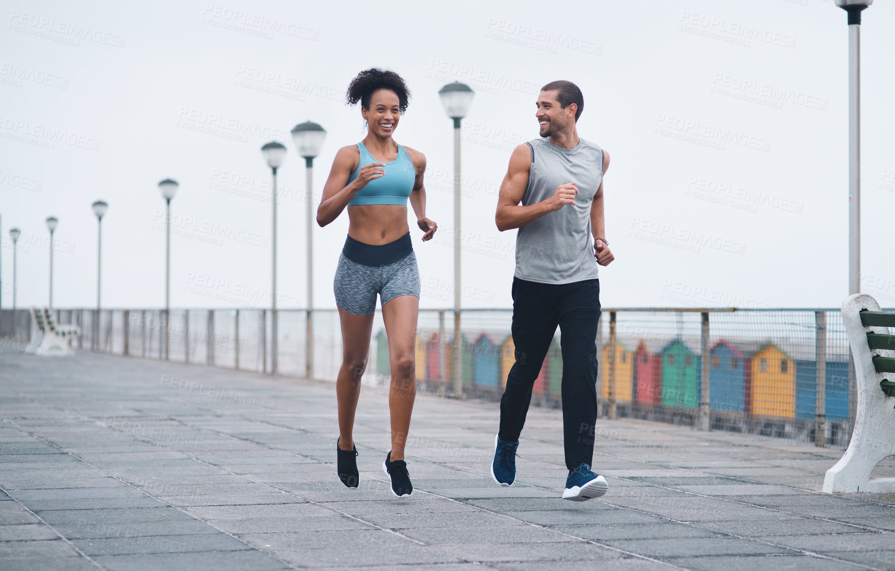 Buy stock photo Shot of two sporty young people exercising together outdoors