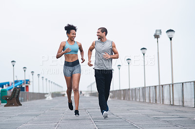 Buy stock photo Shot of two sporty young people exercising together outdoors