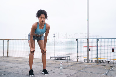 Buy stock photo Black woman, fitness and tired outdoor with music in morning for cardio workout, wellness and health. Athlete, sports and break by beach with water bottle for running, exercise and marathon training