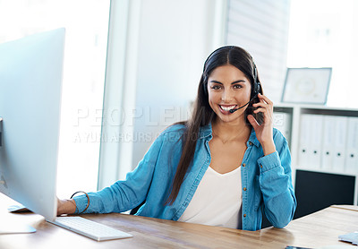 Buy stock photo Portrait of a young businesswoman wearing a headset while working on a computer in an office
