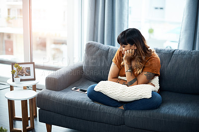 Buy stock photo Shot of a woman looking upset while staring at her cellphone