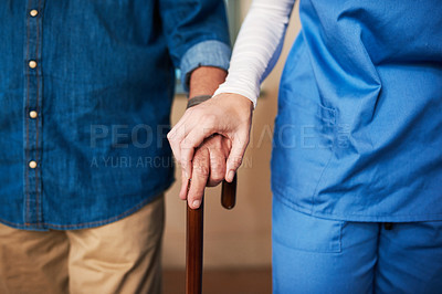 Buy stock photo Shot of a young nurse assisting a senior man who's walking with a cane