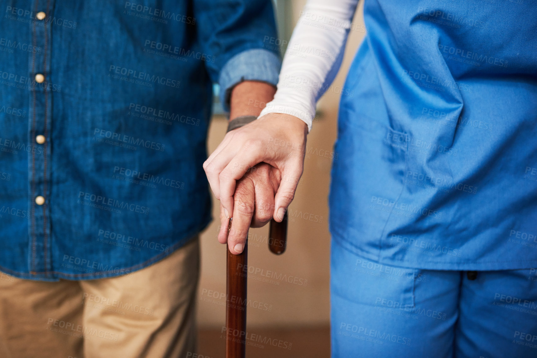 Buy stock photo Shot of a young nurse assisting a senior man who's walking with a cane