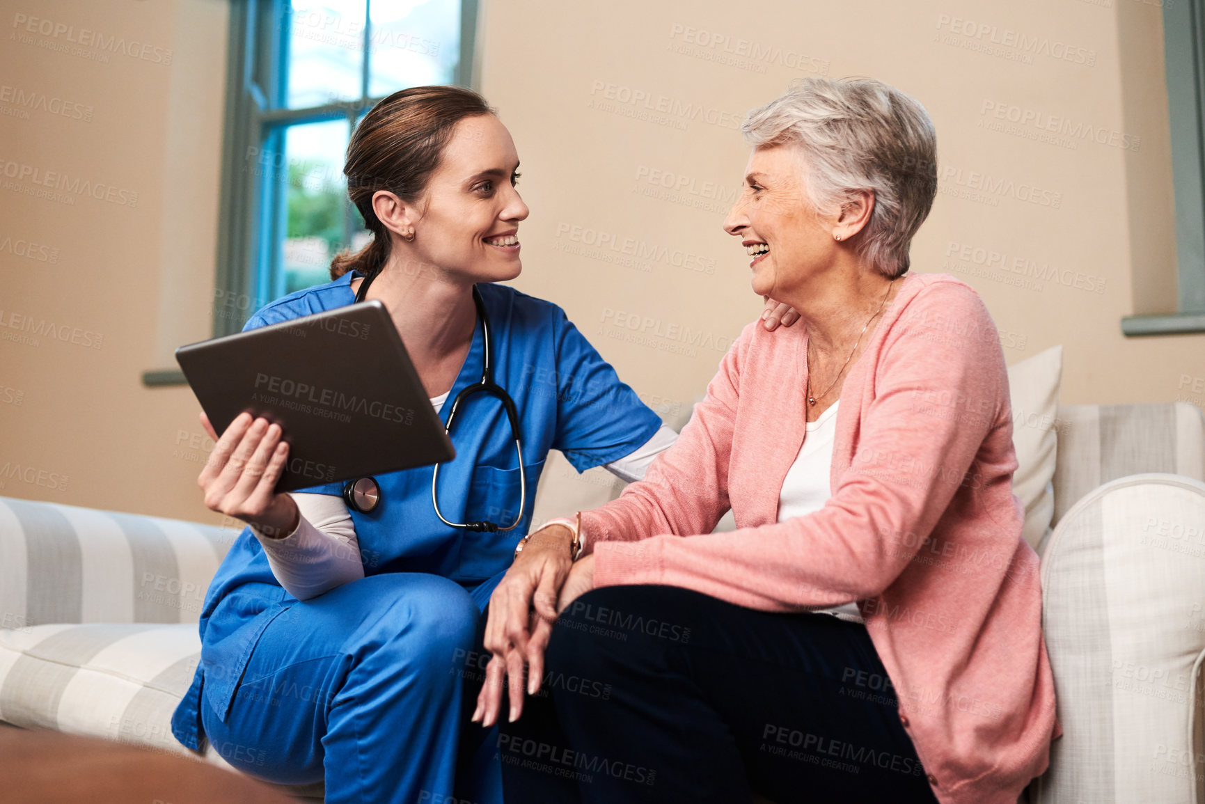 Buy stock photo Shot of a female nurse showing her senior patient something on a digital tablet