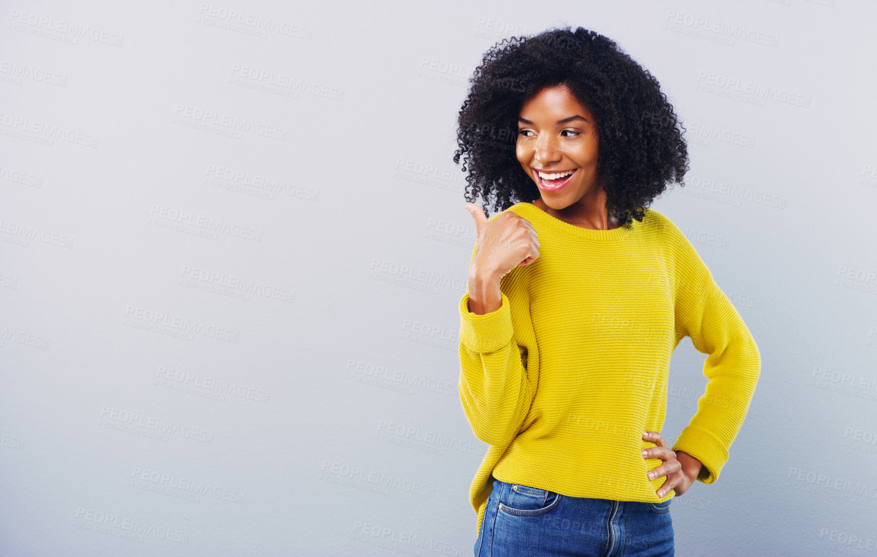 Buy stock photo Studio shot of an attractive young woman pointing at copy space against a grey background