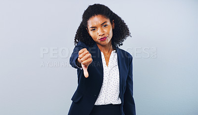Buy stock photo Studio shot of an attractive young businesswoman giving thumbs down against a grey background