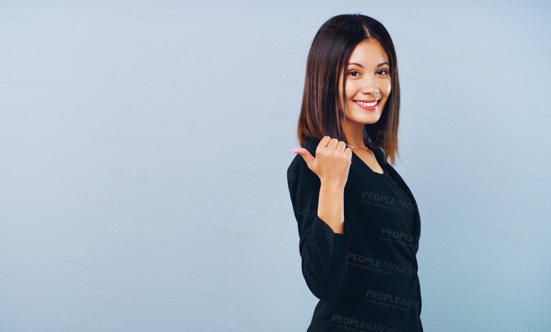 Buy stock photo Studio shot of an attractive young businesswoman pointing at copy space against a grey background