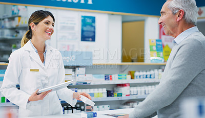 Buy stock photo Shot of a pharmacist assisting a customer in a chemist