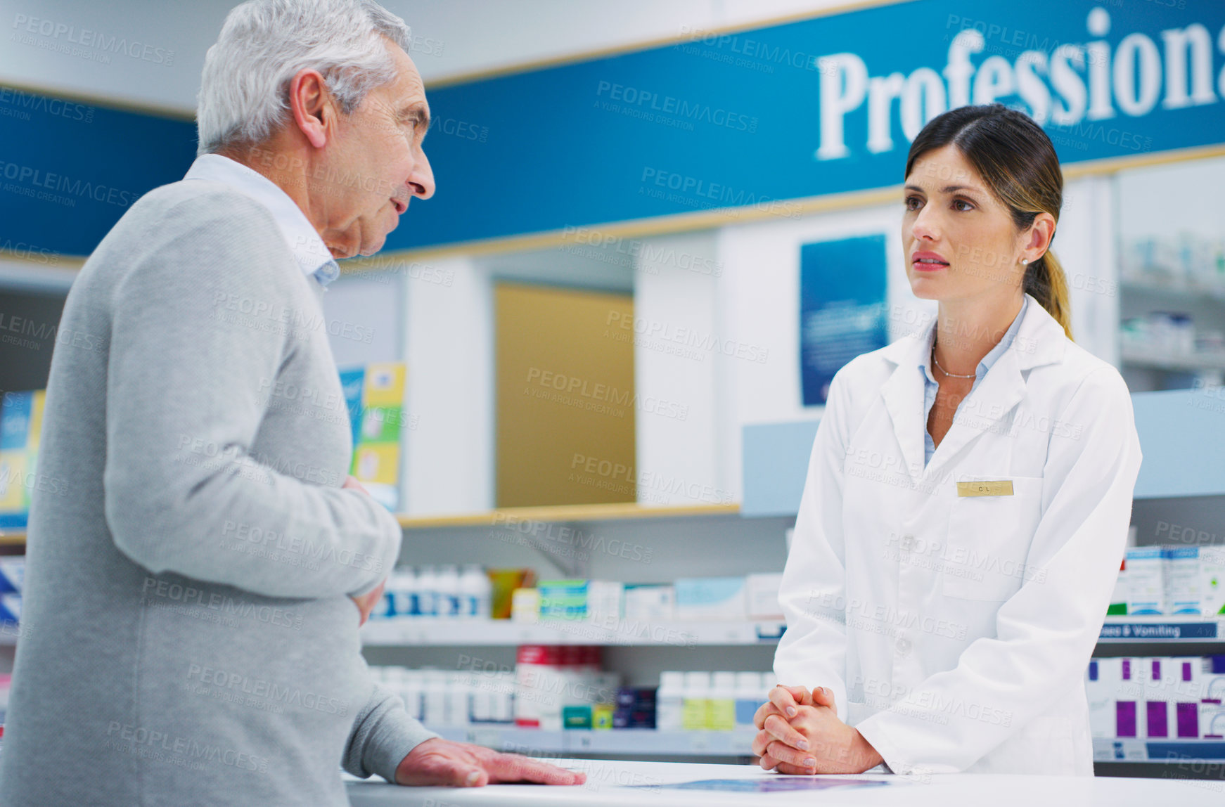 Buy stock photo Shot of a pharmacist assisting a customer in a chemist