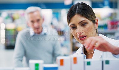 Buy stock photo Shot of a pharmacist assisting a customer in a chemist