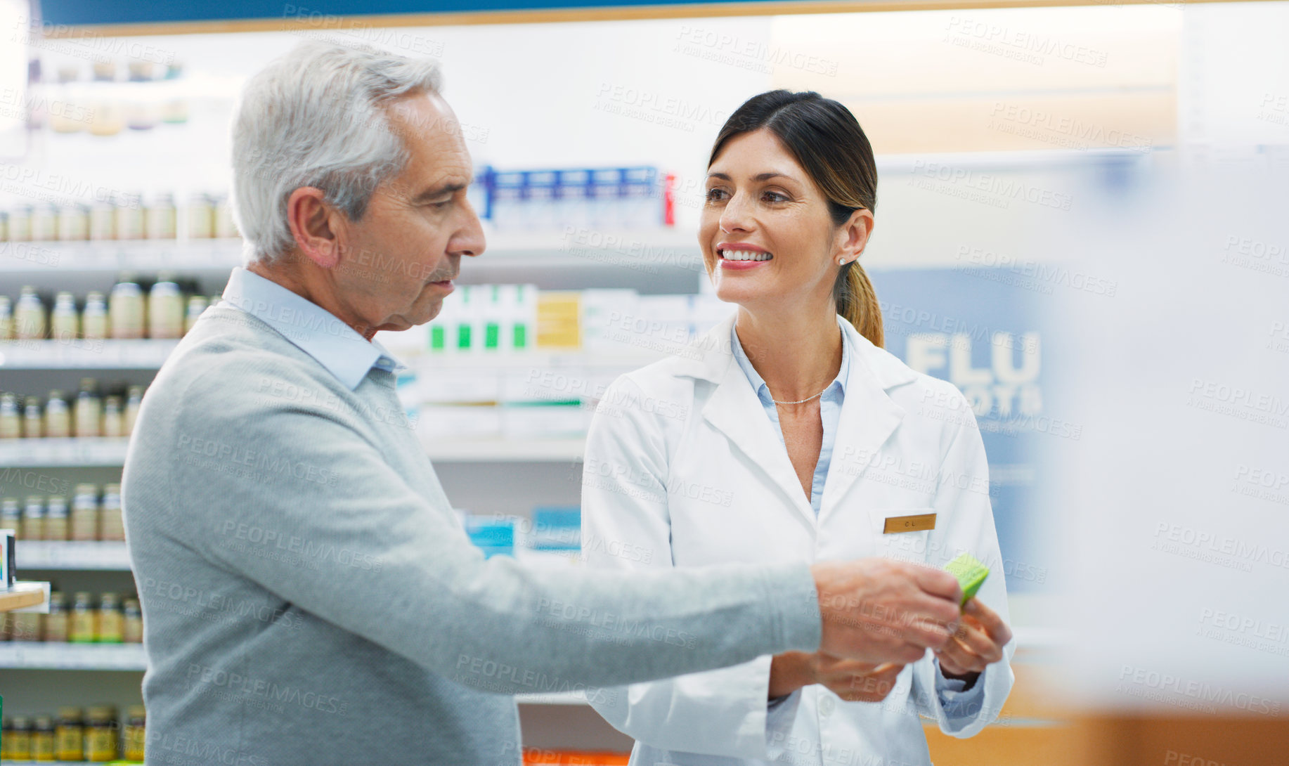 Buy stock photo Shot of a pharmacist assisting a customer in a chemist