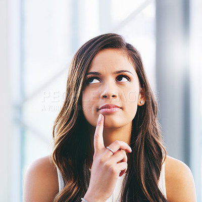 Buy stock photo Shot of a young businesswoman looking away thoughtfully in a modern office