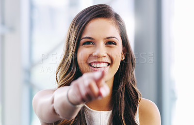 Buy stock photo Portrait of a confident young businesswoman pointing at you in a modern office