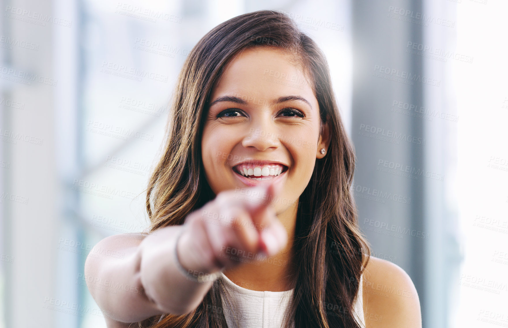 Buy stock photo Portrait of a confident young businesswoman pointing at you in a modern office