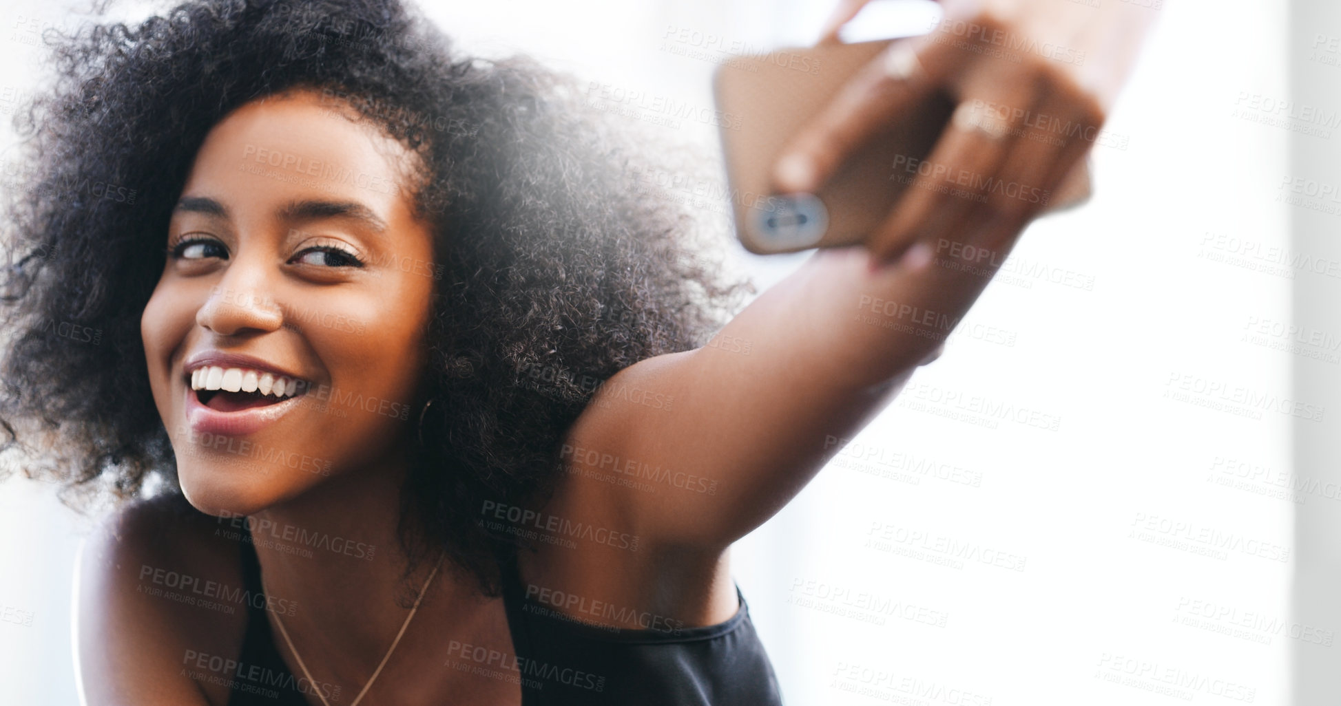 Buy stock photo Shot of a confident young woman taking a selfie with her smartphone