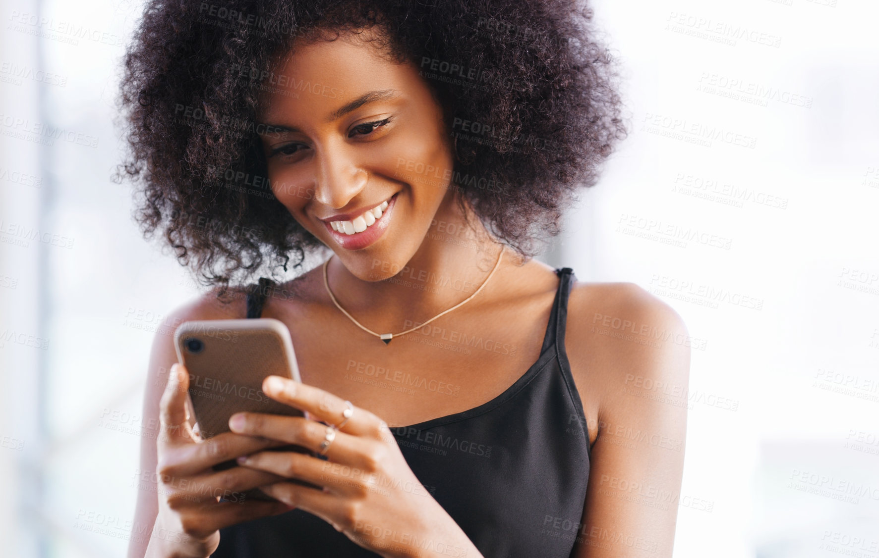 Buy stock photo Shot of a happy young woman using a smartphone