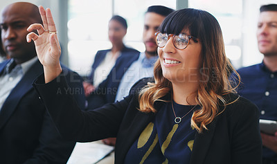 Buy stock photo Shot of a young businesswoman sitting in the audience of a business conference and raising her hand